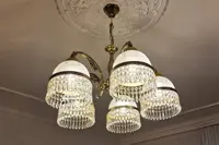 Brass chandelier with five glass domes and crystal pendants photographed from below
