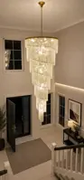 Spiral crystal light fixture in a double-height entrance hall with a staircase